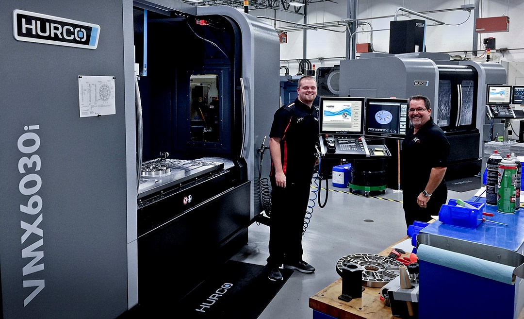 employees at john force racing in front of their Hurco VMX6030i CNC machining center